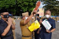 Bupati Garut, Rudy Gunawan melakukan penyerahan seribu sepatu secara simbolis kepada masyarakat Kabupaten Garut dari Badan Amil Zakat Nasional (BAZNAS) Kabupaten Garut saat melaksanakan apel gabungan terbatas di Lapangan Sekretariat Daerah (Setda), Kecamatan Tarogong Kidul, Kabupaten Garut, Senin (13/9/2021). (Foto: Deni Seftyan/ Diskominfo Garut)