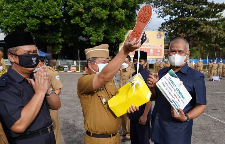 Bupati Garut, Rudy Gunawan melakukan penyerahan seribu sepatu secara simbolis kepada masyarakat Kabupaten Garut dari Badan Amil Zakat Nasional (BAZNAS) Kabupaten Garut saat melaksanakan apel gabungan terbatas di Lapangan Sekretariat Daerah (Setda), Kecamatan Tarogong Kidul, Kabupaten Garut, Senin (13/9/2021). (Foto: Deni Seftyan/ Diskominfo Garut)