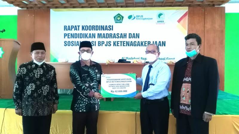 SERAHKAN. Kepala BPJS Ketenagakerjaan Cabang Garut Widya Satrianto Menyerahkan Santunan Jaminan Kematian (JKM) Kepada Ahli waris salah seorang tenaga Pendidik keagamaan, yang diterima secara simbolis oleh Kepala Kementrian Agama (Kemenag) Kabupaten Garut, Dr. H. CECE HIDAYAT. M.SI di Aula Yayasan Pendidikan Al Masduqi, Jalan KH. Mashduqi Nomor 67, Kampung Pasawahan, RT.2/RW.2, Pananjung, Tarogong Kaler, Rabu (29/9/2021).