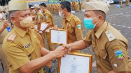 PENGHARGAAN. Kepala Kelurahan Kota Wetan, Galih Mawariz SE SIP M Si,  menerima Piagam Penghargaan Kelurahan Cepat Berkembang yang di serahkan oleh Sekda KAbupaten Garut H Nurdin Yana, saat Apel gabungan di LApangan Setda garut, Senin (15/11/2021)