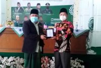 SERAHKAN Ketua MUI Kabupaten Garut, KH Sirojul Munir menyerahkan plakat Ketua MUI Pusat DR. KH M Cholil Nafis, Lc. MA.