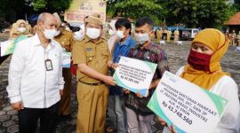 Bupati Garut, Rudy Gunawan di damping Oleh Kepala BPJS Ketenagakerjaan Cabang Garut, Widya Satriyanto, menyerahkan Santunan Jamiinan Kematiak, saat Apel Gabungan terbatas di Lapangan Setda Garut, Senin (13/12/2021)..