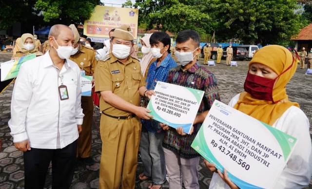 Bupati Garut, Rudy Gunawan di damping Oleh Kepala BPJS Ketenagakerjaan Cabang Garut, Widya Satriyanto, menyerahkan Santunan Jamiinan Kematiak, saat Apel Gabungan terbatas di Lapangan Setda Garut, Senin (13/12/2021)..