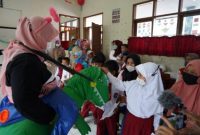 Nakes mengenakan aksesoris unik, agar vaksinasi anak lebih rilek dan ceria