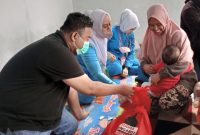 BINGKISAN.Anggota DPRD Fraksi PDI-Perjuangan Yudha Puja Turnawan memberikan bingkisan kepada anak yang di Imunisasi, kegiatan Bulan Imunisasi Anak Nasional (BIAN) di Posyandu RW 03 Kelurahan Karangmulya Kecamatan Karangpawitan, Kabupaten Garut, Kamis (4/8/2022).