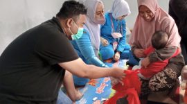 BINGKISAN.Anggota DPRD Fraksi PDI-Perjuangan Yudha Puja Turnawan memberikan bingkisan kepada anak yang di Imunisasi, kegiatan Bulan Imunisasi Anak Nasional (BIAN) di Posyandu RW 03 Kelurahan Karangmulya Kecamatan Karangpawitan, Kabupaten Garut, Kamis (4/8/2022).