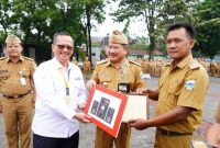 Bupati Garut, Rudy Gunawan menyerahkan penghargaan dari Kantor Pelayanan Pajak (KPP) Pratama Kabupaten Garut kepada beberapa Kepala Desa (Kades) atas Kepatuhan Pembayaran Pajak Tahun 2021-2022, bersamaan dengan pelaksanaan Apel Gabungan di Lapang Sekretariat Daerah (Setda) Garut, Jalan Pembangunan, Kecamatan Tarogong Kidul, Kabupaten Garut, Senin (13/2/2023). (Foto: Muhamad Azi Zulhakim/ Diskominfo Garut)