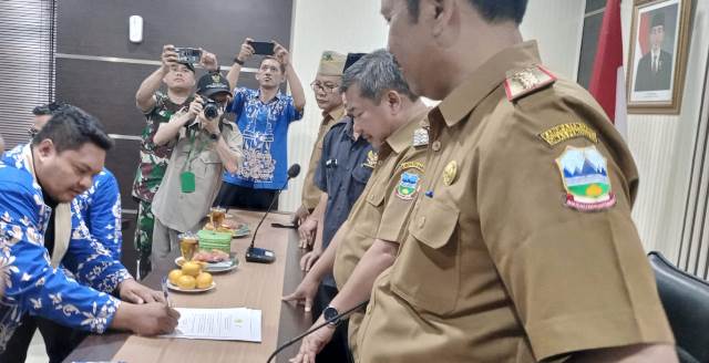 Kepala Dinas Pendidikan Kabupaten Garut Ade Manadin SPd, MPD saat menyaksikan penandatanganan MoU antara Forum Aliansi Guru dan Karyawan (Fagar), Pemerintah Daerah dan BAZNAS Kabupaten Garut, Di Ruang Rapat Sekretariat Daerah (Setda) Kabupaten Garut, Kecamatan Garut Kota, Kabupaten Garut, Senin (20/02/2023).
 