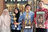 BANGGA. Aleandro dan Gina Nurul Azkiya Siswa MAN Garut yang menjuarai Supenova 4.0 Olimpiade Kimia ingkat Provinsi Jawa Barat menunjukan Piala didampingi Waka KesiswaanHendra Iskandar, s.pd, M.Pmat dan Guru Pembimbing di MAN 1 Garut, Rabu (22/2/2023)