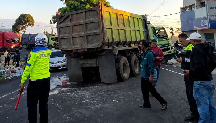 Petugas Polsek Malangbong melakukan olah TKP kecelakaan antara Fuso Dump Truck dan Truk Tronton di Jalan Raya Malangbong-Tasikmalaya, Kabupaten Garut, Selasa (9/6/2026).