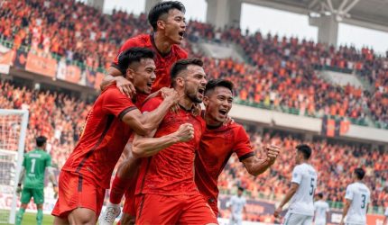 Ilustrasi pemain sepak bola merayakan gol di stadion Indonesia.