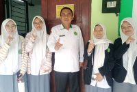 Plt Kepala MAN 1 Garut berfoto bersama siswi usai melaksanakan Tes Kemampuan Akademik (TKA) di ruang komputer MAN 1 Garut, Jalan Jend. Ahmad Yani Koropeak, Suci, Kecamatan Karangpawitan, Kabupaten Garut, Selasa (27/10/2026).