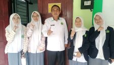 Plt Kepala MAN 1 Garut berfoto bersama siswi usai melaksanakan Tes Kemampuan Akademik (TKA) di ruang komputer MAN 1 Garut, Jalan Jend. Ahmad Yani Koropeak, Suci, Kecamatan Karangpawitan, Kabupaten Garut, Selasa (27/10/2026).