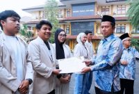 Rektor Universitas Garut, Dr. Irfan Nabhani, S.E., M.T., menyerahkan penghargaan kepada pemenang Lomba Video KKN Tematik UNIGA Tahun 2026 dalam apel pagi di halaman kampus Universitas Garut, Senin (12/10/2026).