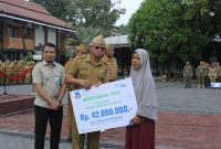 Sekretaris Daerah Kabupaten Garut, Nurdin Yana, memimpin penyerahan simbolis manfaat Jaminan Kematian kepada ahli waris dalam apel gabungan di Setda Garut, Senin (12/10/2026).